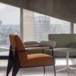 Modern high-rise apartment living room with lounge chairs and floor-to-ceiling city views