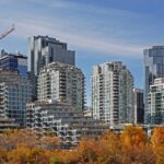 Modern residential condo towers above autumn trees in Calgary