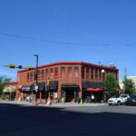 Red-brick heritage corner building with storefronts in Kensington, Calgary