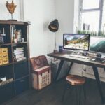 Bright home office with wooden desk, bookshelves and computer