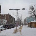 Snow-covered inner-city street lined with condo buildings in winter, Calgary